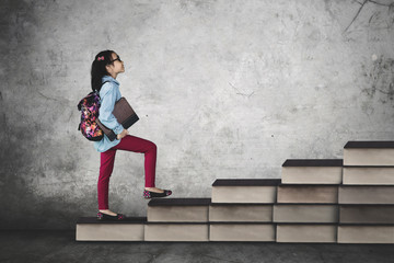 Schoolgirl steps on books stair