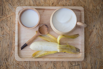 Soy milk dessert made of tofu with fresh banana on wood tray