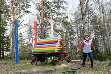 Obraz na płótnie Canvas Beautiful girl pulls a cart with colored pencils