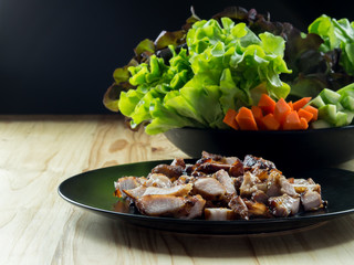 Grilled pork in a plate and Green leafy vegetables, On pine floor.