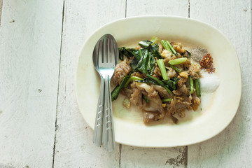 Thai Food Fried noodle with pork. on White wood table.