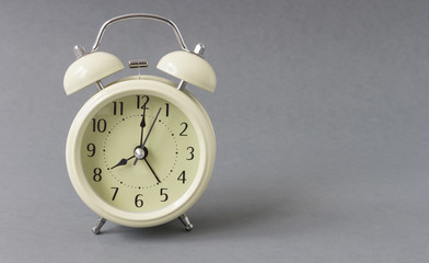 Retro alarm clock on grey background, time concept