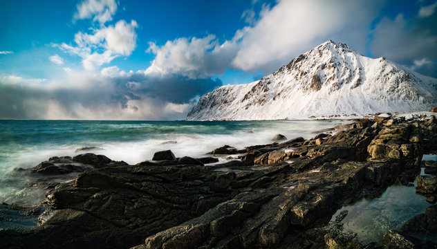 Stones on coastline and snow mountain  in Norway