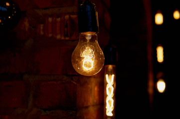 Edison light bulb hanging on a long wire. Cozy warm yellow light. Retro