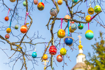 Painted Easter eggs on a tree branch.The temple or church in the background