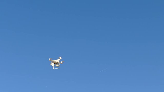 Swarm of Drones flying everywhere in the sky. This blue sky can be chroma keyed so that you can place these drones in another sky or setting with ease.