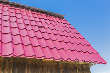 The roof of the country house is covered with metal roofing