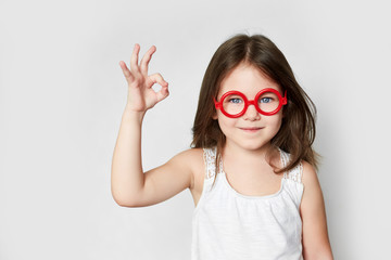 smiling little girl in red toy glasses