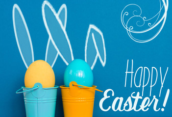 Easter eggs with Rabbit ears in colored buckets on white, selective focus image, Card Happy Easter 