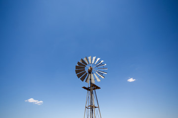 Close up wide angle image of a windmill / windpomp with static blades in the Tankwa Karoo in South Africa on a hot summersday