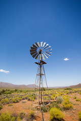 Close up wide angle image of a windmill / windpomp with static blades in the Tankwa Karoo in South Africa on a hot summersday