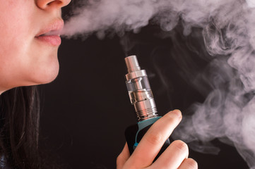 A woman smokes an electronic cigarette