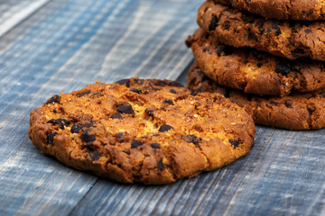 Cookies with chunks of chocolate close-up. Selective focus. In the background a column with biscuits