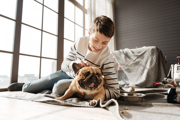 Smiling boy scratching head of his pet
