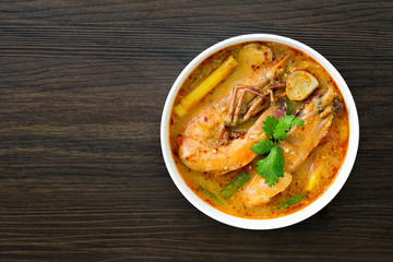 Tom yum kung in white bowl on wooden table, Still life image and Select focus, space for text