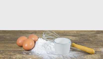Egg white and yolk in floor with whip on the kitchen table