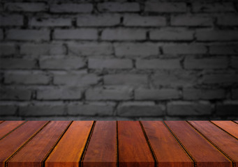 Selected focus empty brown wooden table and wall texture or old black brick wall blur background image. for your photomontage or product display