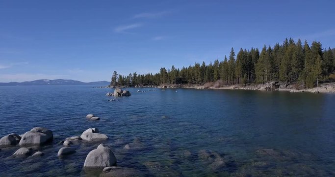 Flying over the surface of Lake Tahoe with boulders in water