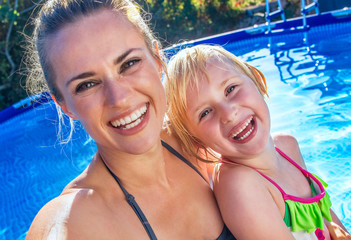 happy active mother and child in swimming pool taking selfie