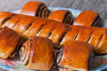 Roll with poppy seeds on a plate. Selective focus.