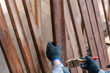 To paint a fence. The man paints a fence.