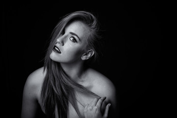 red head model with an edgy personality looking sexy in a dark studio with edgy lighting