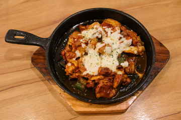 Rice cake korean food or Topokki  with Cheese in Hot Pan on wooden table,korean food,korea food