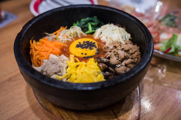 Steaming  Bibimbap in hot Bowl on wooden table,pibimpap korean food,korea food