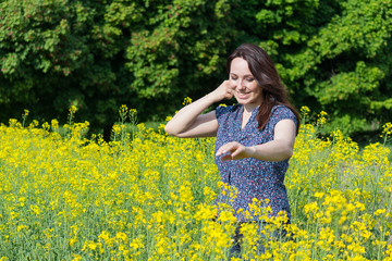 Beautiful woman in a yellow flowers field. Peoples