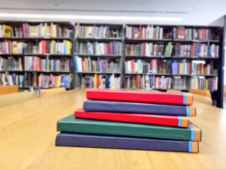 Old books on the wooden table in the library. Selective focus with blurred background.