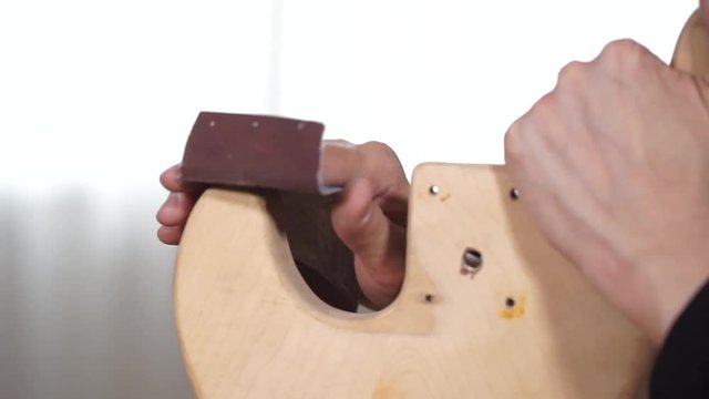 The master of repair of guitars repairs an electric guitar