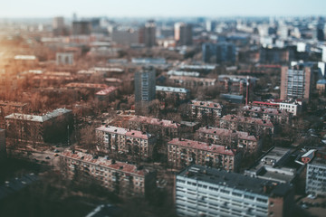 Fototapeta na wymiar True tilt shift view from high point of residential district in metropolitan city in the morning, with multiple houses, road junction in foreground and blurred background with strong bokeh