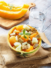 Vegan cantaloupe melon salad with tofu cheese, herbs and cucumber. Healthy summer fresh lunch