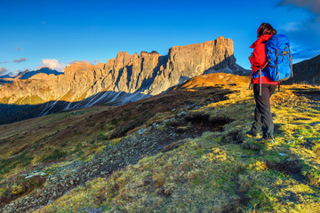 Sporty hiker woman with backpack on top of a mountain
