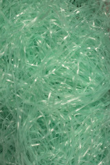 This is a photograph of Turquoise shredded plastic fake Easter grass background