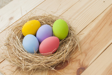 Easter Eggs in nest on wood background