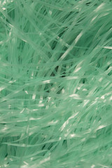 This is a photograph of Turquoise shredded plastic fake Easter grass background