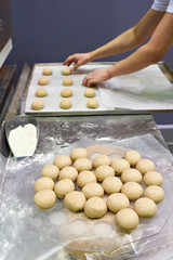 Cook prepares buns for baking