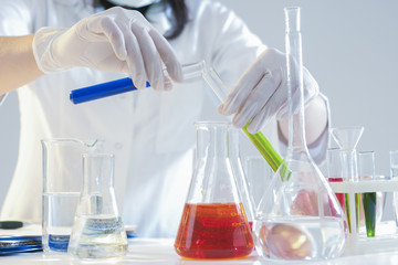 Research and Science Concepts. Closeup of Hands of Female Laboratory Staff Working With Liquids Specimens in Flasks in Laboratory During Experiment.