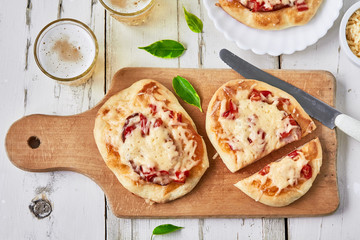 Italian pizza with salami, peppers and tomatoes and a glass of beer. top view