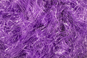 This is a photograph of Purple shredded plastic fake Easter grass background