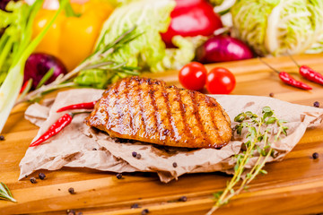 Grilled chicken breast on wooden board