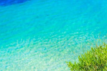 Summer beach with shiny sparkling sea water. Blurred background.
