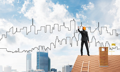 Man architect draw silhouette of modern city on blue sky. Mixed media
