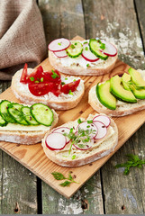 Healthy sandwiches with avocado, cherry tomato, cucumber, radish,cream cheese and flax seeds