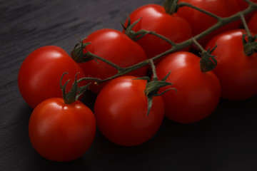 organic fresh cherry tomatoes on black board background