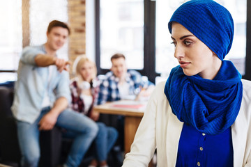 Group of students humiliating young muslim woman