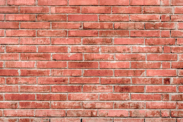 Old red brick wall with cracks and scratches. Horizontal wide brickwall background. Distressed wall with broken bricks texture. Vintage house facade.
