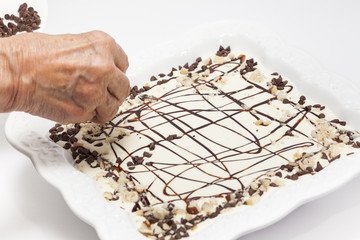 Napoleon dessert preparation : Decorating with chocolate sauce, chips and nuts