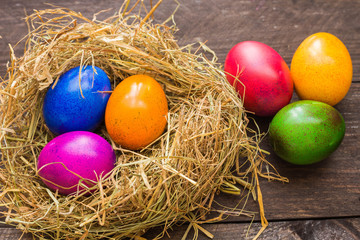 Fototapeta na wymiar Wielkanocne kolorowo malowane jajka na drewnianym tle.